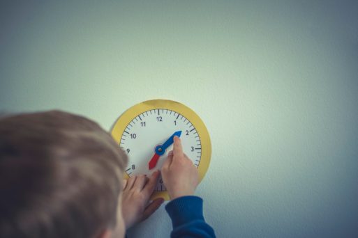 child moving hand of a paper clock 