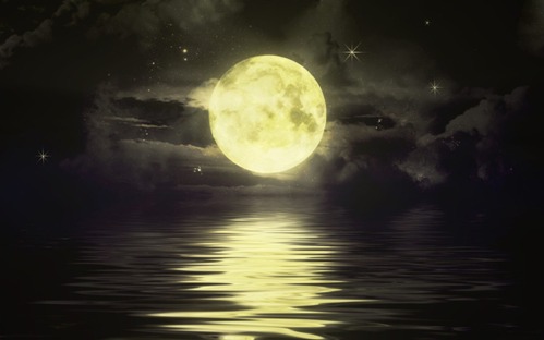 the moon shining over a body of water at night 