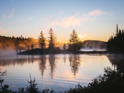 a sunrise behind a lake