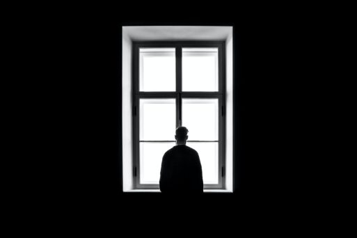 man alone by a window black and white image