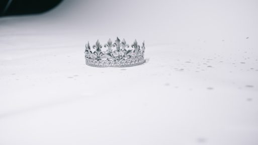 a silver crown sitting on a white background