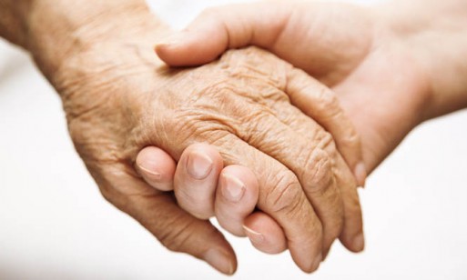 caregiver holding the hand of terminally ill patient