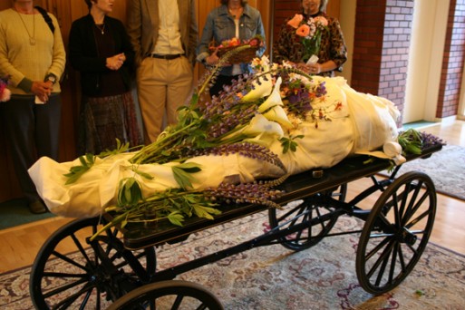 Green burial cart with flowers