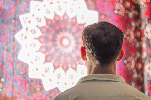 A man looking at a colorful pattern on the wall