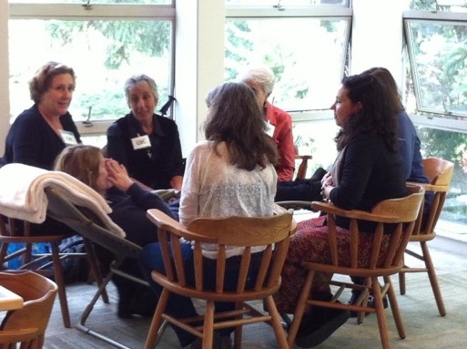 Women gather to sing to a person posed as dying at the "Death OK" conference