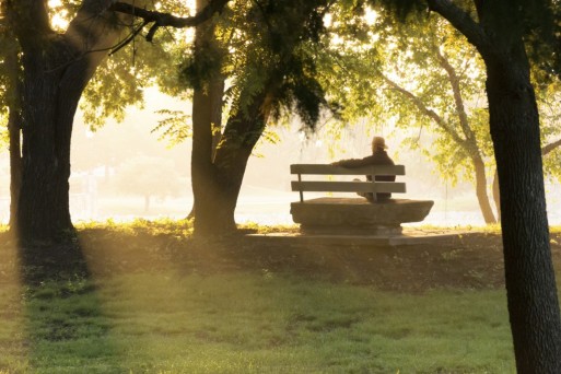 Grieving person sitting outside on a park bench