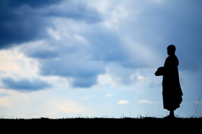 Buddhist monk looking at a cloudy sky