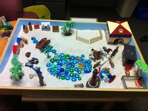 Sand tray therapy using symbolic objects 