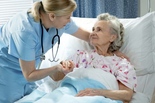 Hospice nurse helping elderly woman