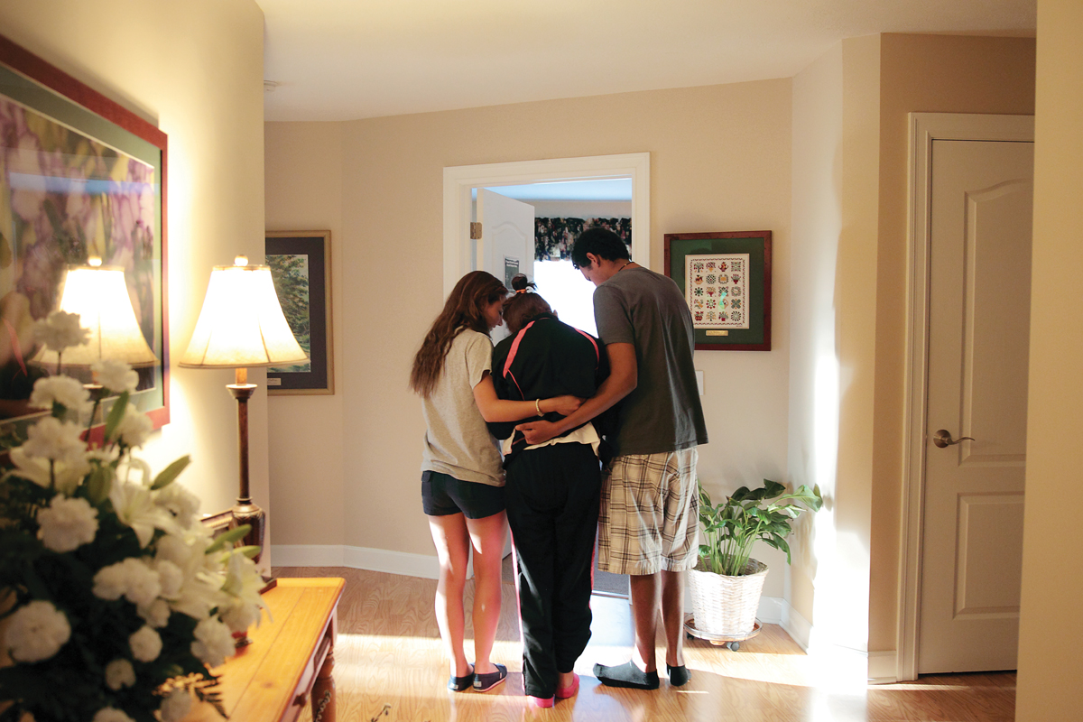 Students helping a hospice resident walk