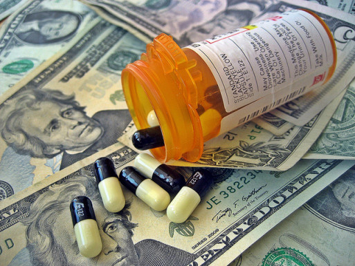 A bottle of pills spilling onto a stack of dollars represents soaring cost of medical care