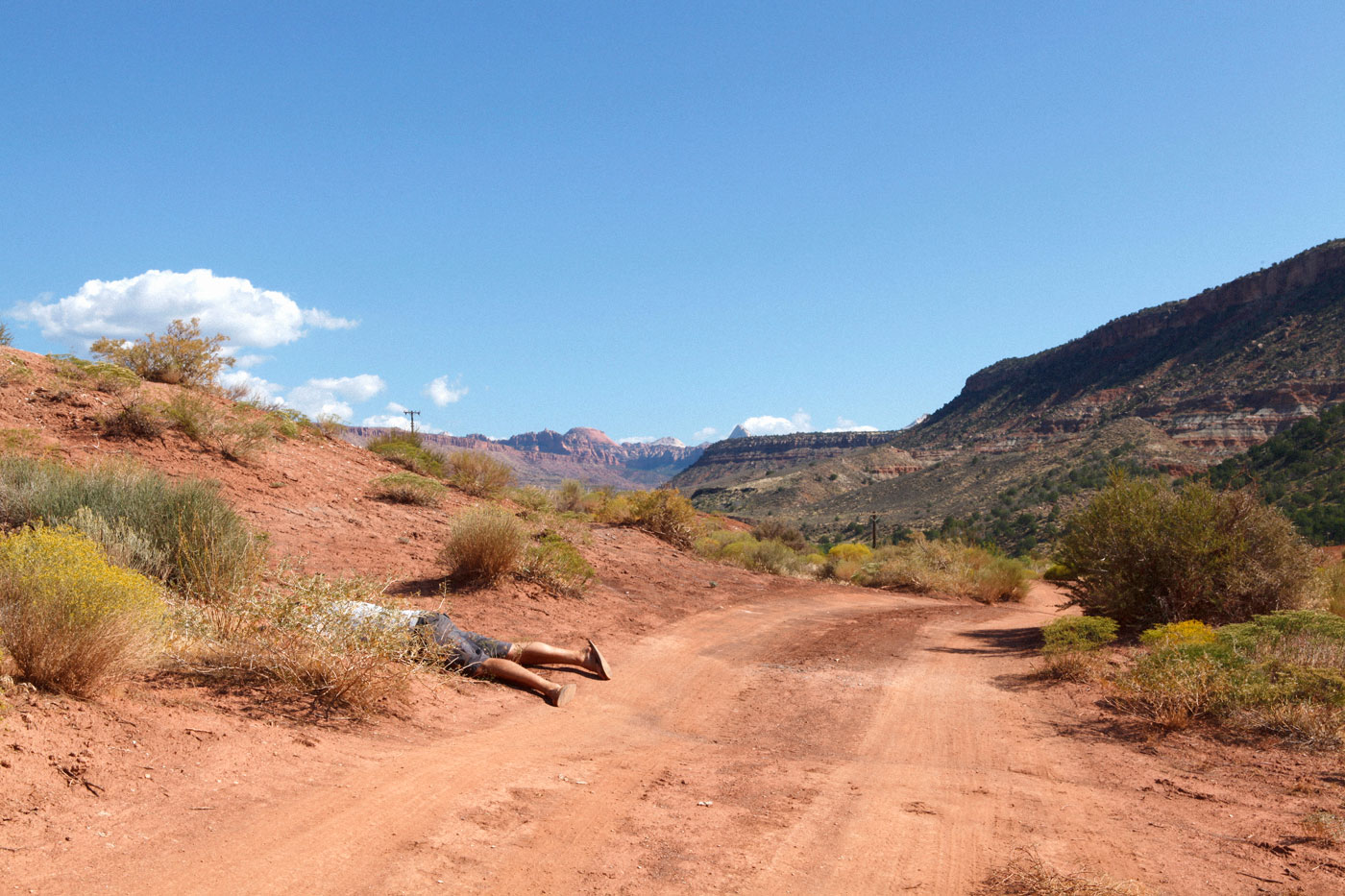 Tom Philips feigning death on a roadside in the desert