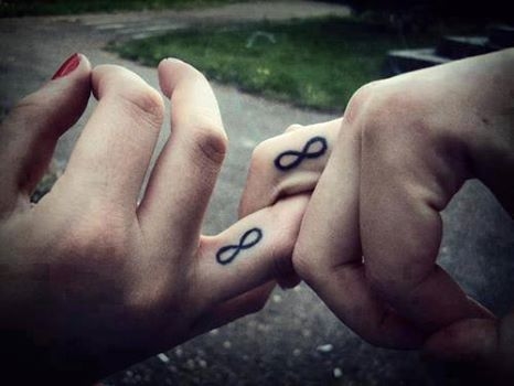Intertwined fingers with infinity symbol speak of eternal love