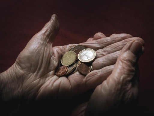Elderly hands holding coins shows money can't buy time