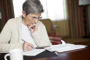 Elderly woman doing taxes for spouse who died