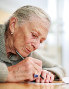 Senior woman writing letter to express end of life wishes
