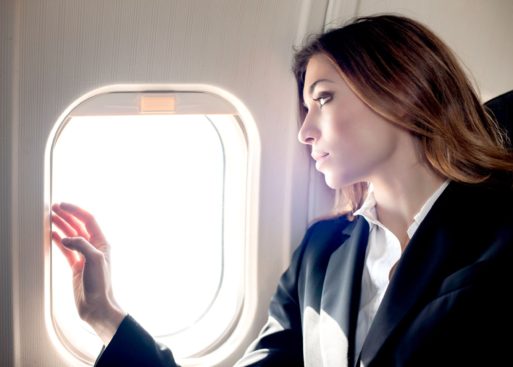 Grieving woman looking out the window of an airplane