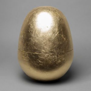 A gold, egg-shaped urn, part of Natlacen's funeral art exhibit