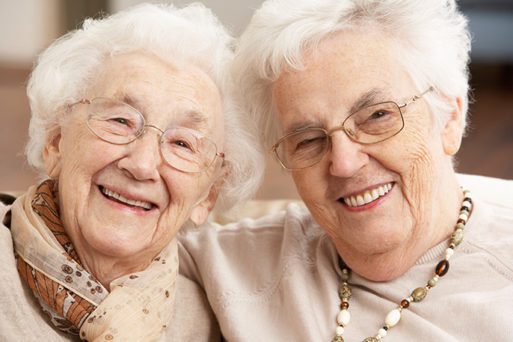 Two smiling healthy elderly women who are likely to outlive men