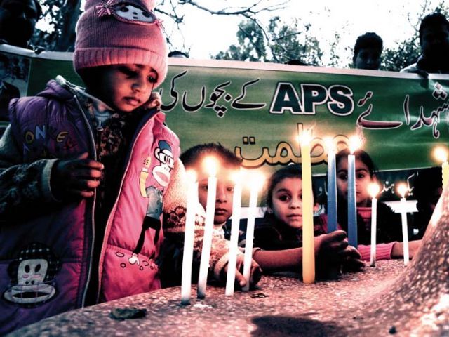Children light candles at a memorial