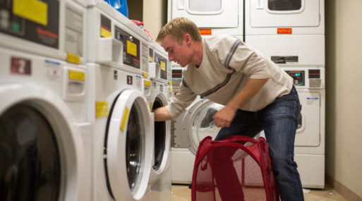 Young man doing laundry reminds us to use time wisely