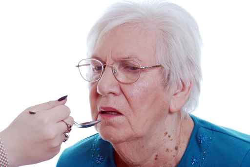 Elderly woman being fed from a spoon