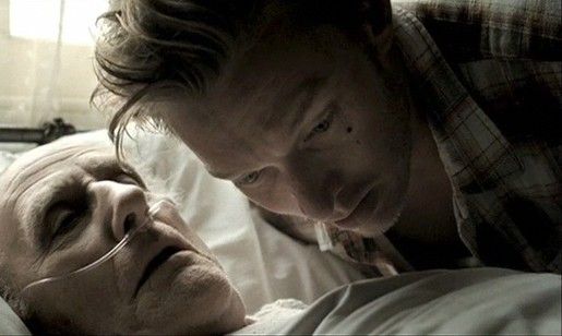 A woman leans over a dying man to hear his ethical will