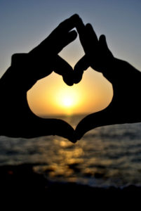 Heart hands at sunset speak of loss and love