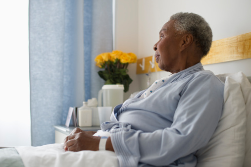 African American women sitting up in bed in hospice