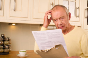 Senior man looking at a high medical bill 