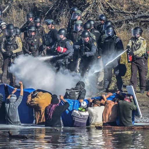 Police in full military gear spray tear gas and pepper spray on people protesting the Dakota Access Pipeline