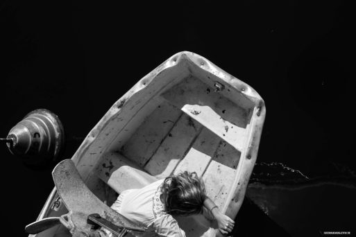 An image of a child looking into the water from a small boat symbolizes the mystery of death and dying 