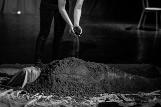 an image of a shrouded body being covered with dirt in death and dying exhibit