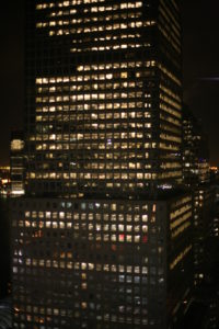 A skyscraper at night, with a few lights still on, symbolizing how a body slowly shuts down during death