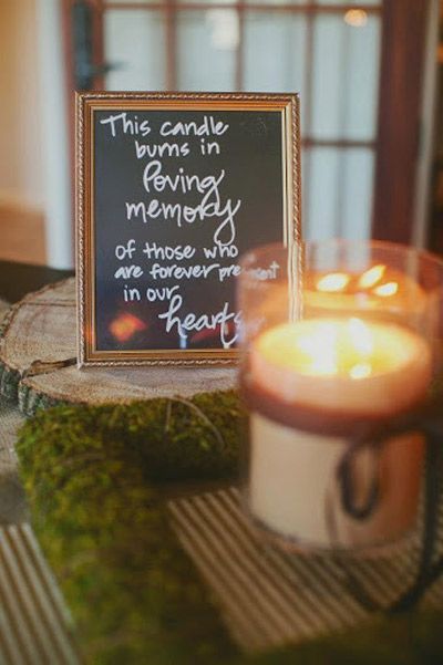 A candle next to a plaque commemorating a loved one is part of a memorial ceremony