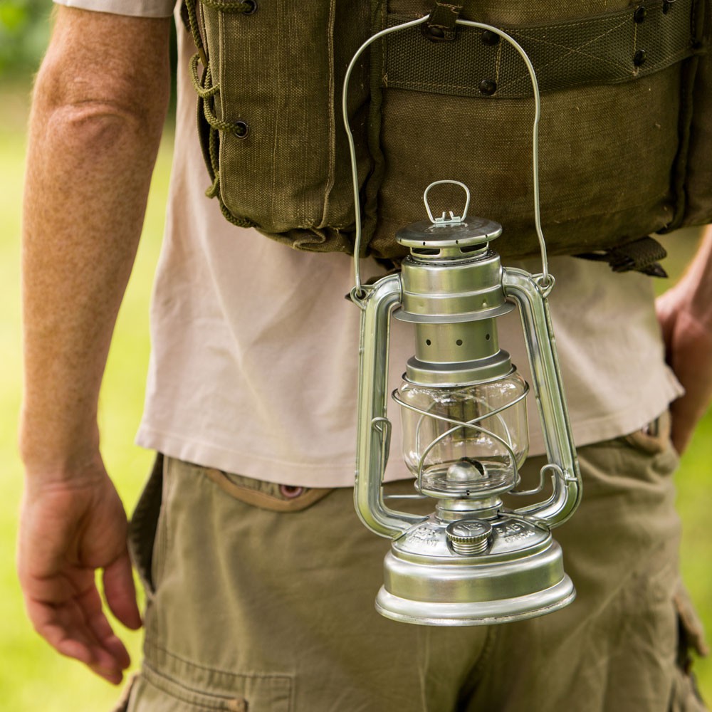 A person carrying a lantern after a storm like the one described in "Remnant"