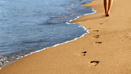 Woman leaving footprints in the sand on beach