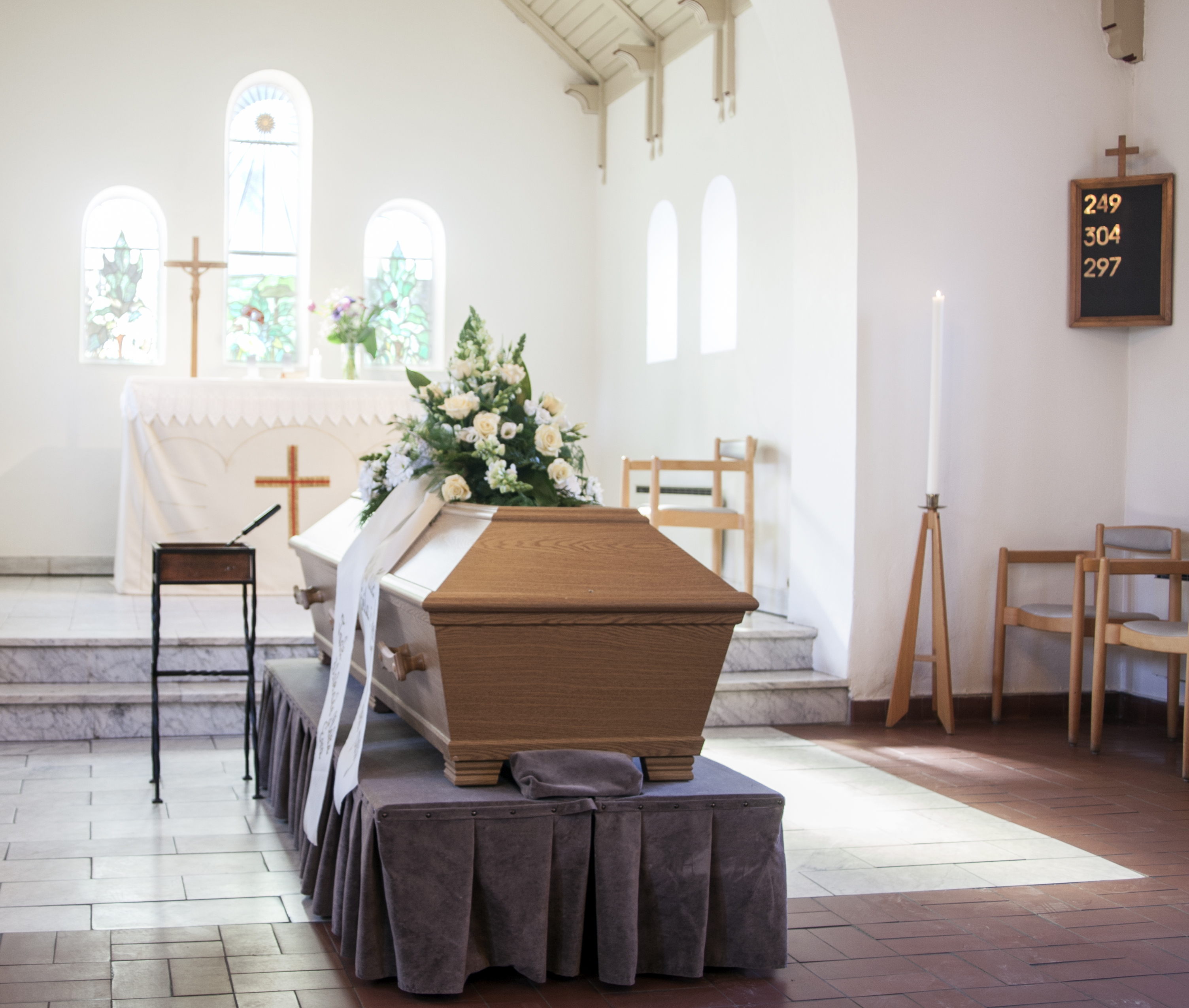 A coffin sits in the center of a memorial room in a funeral home