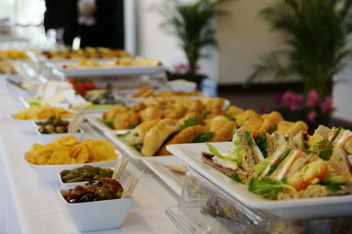 A table filled with food and drink served in funeral homes, including sandwiches and other small appetizers 