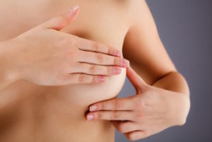 Woman examining her breasts rather than gettingregular mammograms