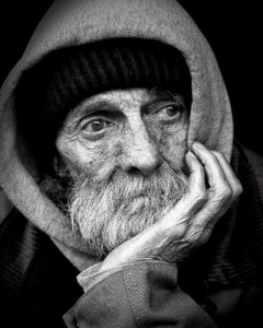 Homeless man with chin in palm