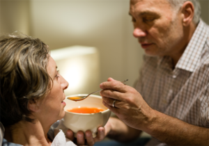 A man feeds his wife soup 