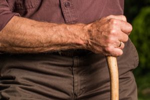 An elderly man holding a cane is one of the country's elder orphans