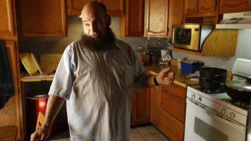 Mohamed Bzeek, who takes in sick foster children, standing in the kitchen