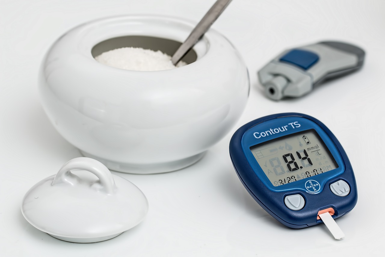 Bowl of sugar, blood sugar reader next to eachother symbolizing diabetes