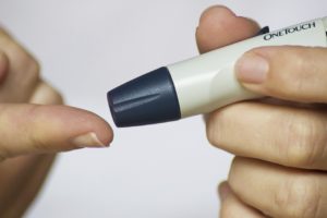 Person with diabetes pricking their finger to test for blood sugar level