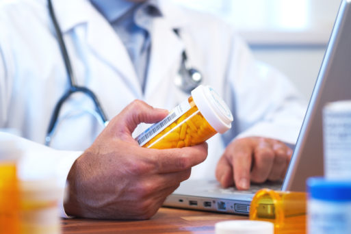 Doctor holding a bottle of opioids for patient
