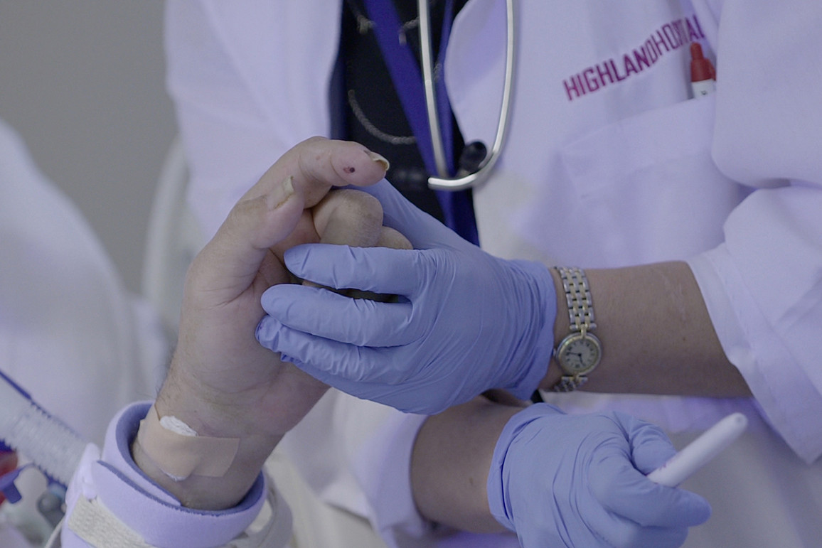 Doctor holds the hand of a patient near death
