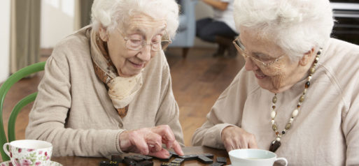 Two elderly women playing scrabble to beat loneliness