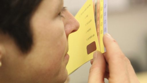 A woman smells a scratch and sniff card that is used in the odor test to detect Alzheimer's and Parkinson's